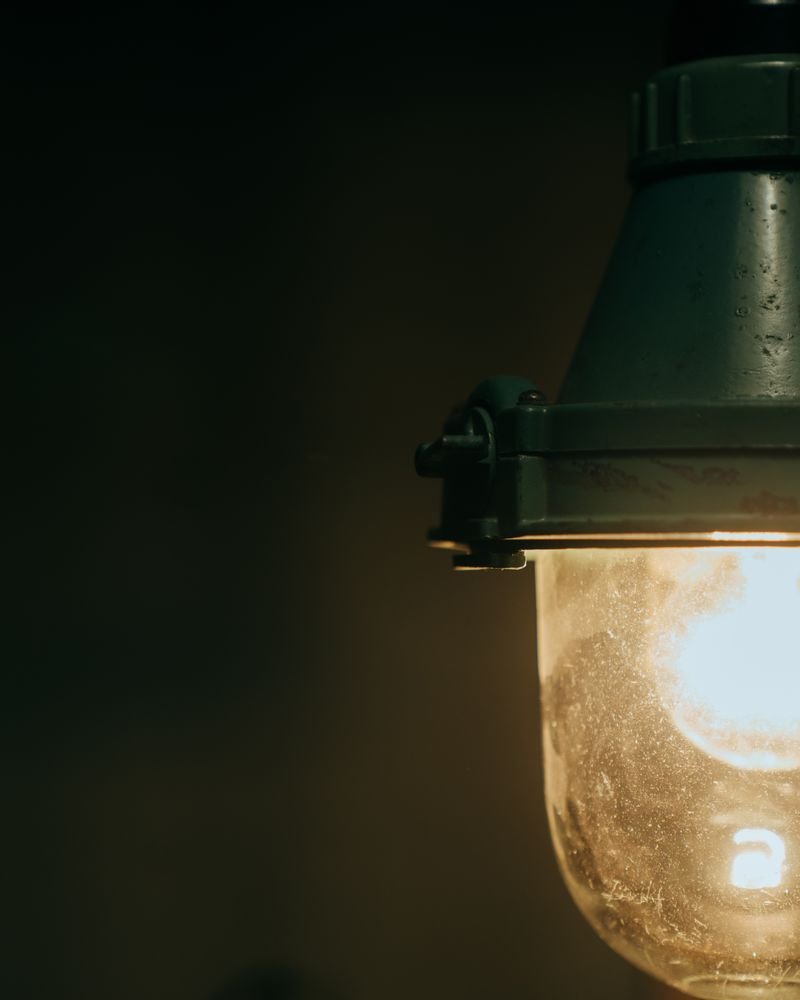 A vintage industrial pendant lamp glowing in a dark room